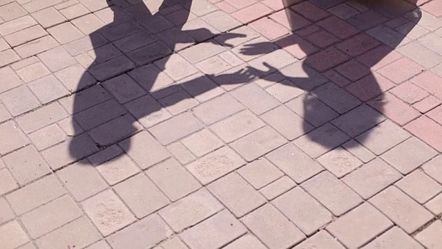 新婚夫妇在柏油路上的影子剪影。