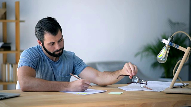 戴眼镜的勤奋学生在桌前做作业