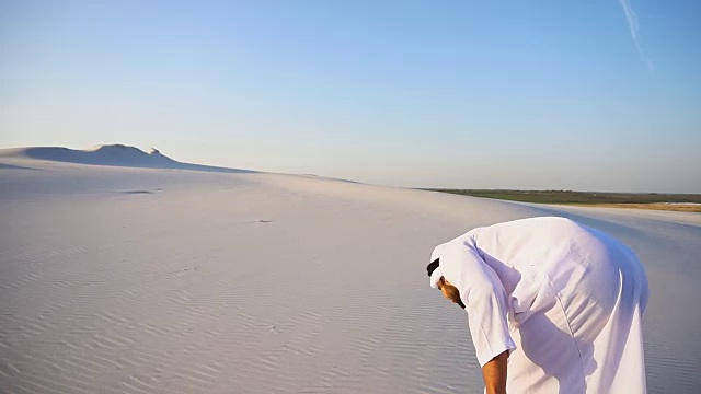 詳情圖-在晴朗的夏日，快樂的阿拉伯酋長走在沙漠的頂端，臉上帶著微笑