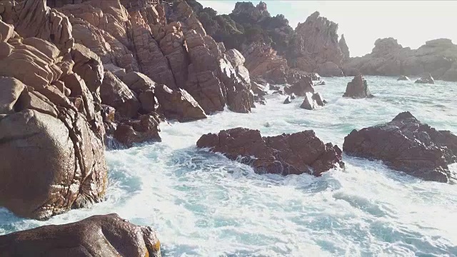 海浪拍打着岩石。无人机拍摄的航拍视频。翡翠海岸，撒丁岛，意大利