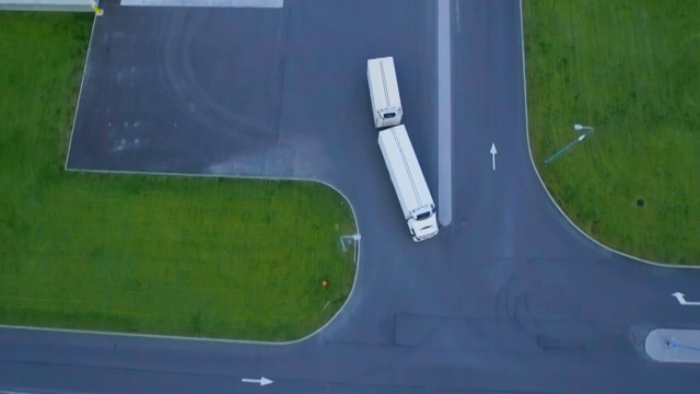 詳情圖-空中拍攝的卡車與掛載半掛車離開工業(yè)倉庫/倉庫大樓/裝卸區(qū)的許多卡車裝載/卸載商品。