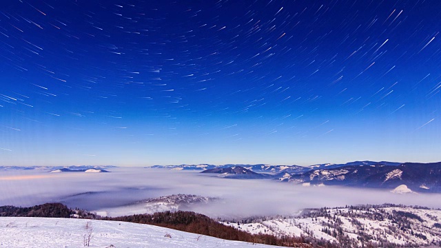 雾在冬天的山上移动，天空是星形的