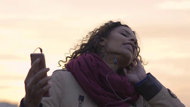 詳情圖-迷人的混血女子聽(tīng)著音樂(lè)，在夕陽(yáng)下翩翩起舞