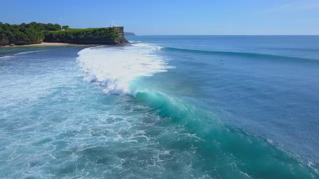 航拍:在阳光明媚的巴厘岛，一名冲浪者从冲浪板上跌落