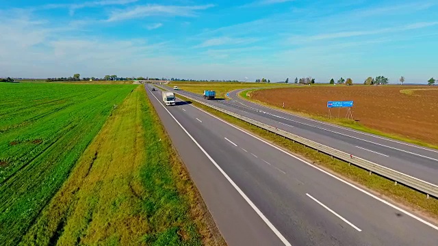 鸟瞰图卡车和汽车行驶在乡村道路上。高速公路上行驶的汽车