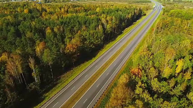 从上面看，汽车在高速公路上通过森林。高速公路路