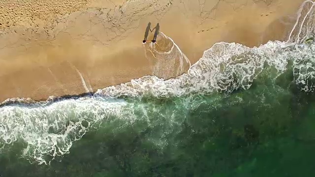 詳情圖-一對(duì)年輕夫婦手牽著手在海灘上散步