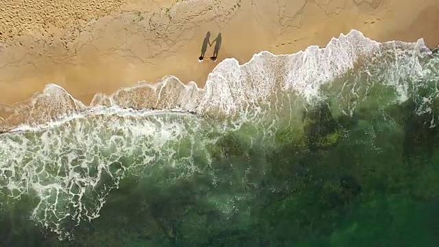 詳情圖-一對(duì)年輕夫婦手牽著手在海灘上散步