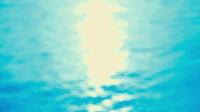 在海边-美丽的无缝环完全散焦4k拍摄的轻微波浪的水面。太阳很低，反射光在水面上闪烁