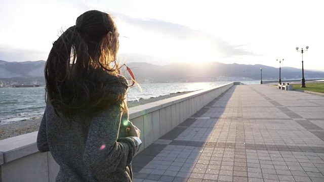 年轻女子穿着帽衫在海滨城市慢跑