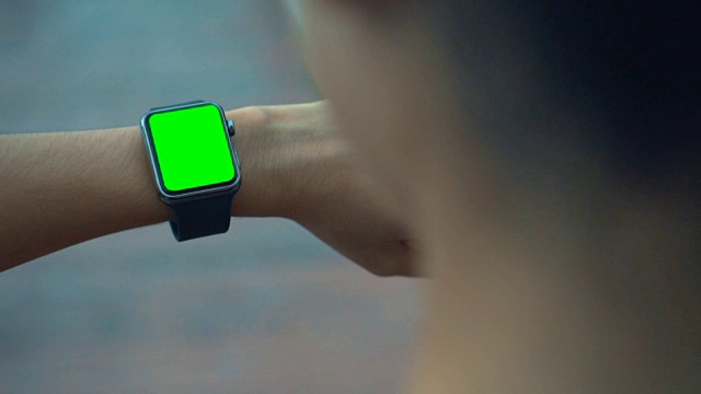 高清慢动作:女人慢跑和看智能手表，绿色屏幕