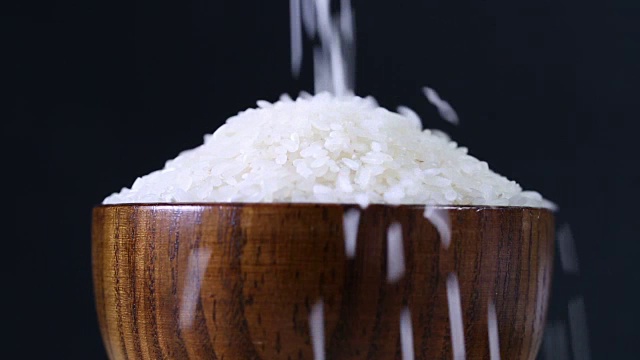 米饭掉到木碗里。
