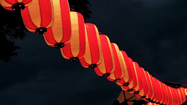 纸红白的日本灯笼在黑暗的天空中闪耀