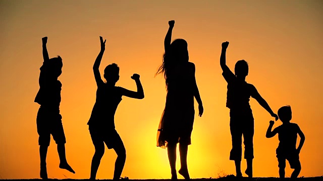 五个孩子在夕阳下跳跃的剪影