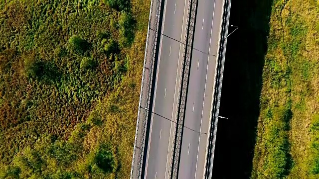 鸟瞰绿地中的高速公路。在郊区道路上行驶的汽车