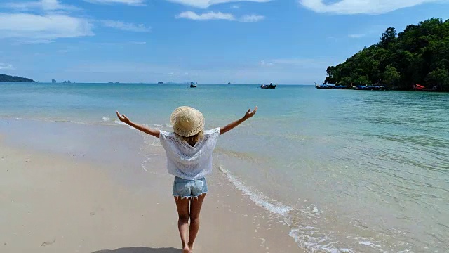 详情图-一个在泰国海滩上走着的女人，跟踪拍摄