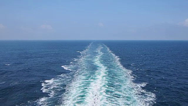 海上有船的尾流。这艘大船后面的水沫一直延伸到地平线。