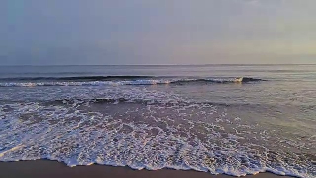 傍晚的海滩上奔流的波浪。鸟瞰图