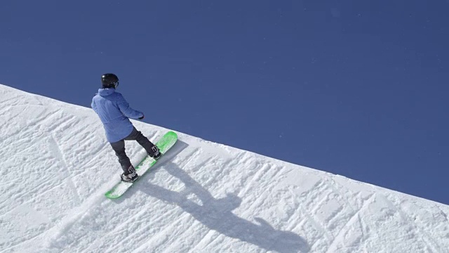 慢动作:年轻的极限职业滑雪板跳高在半管雪公园