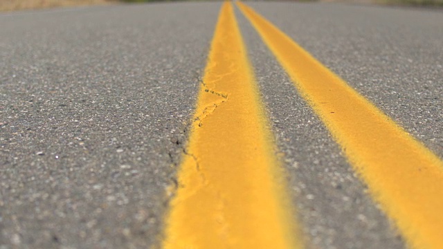 近距离观察:双黄线道路在秋天穿过彩色森林