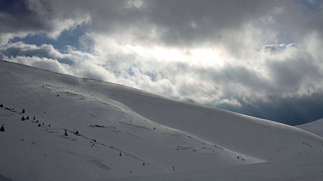 壮观的天空和白雪皑皑的群山中的阳光