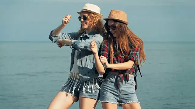 年轻的女子在海边享受和跳舞。