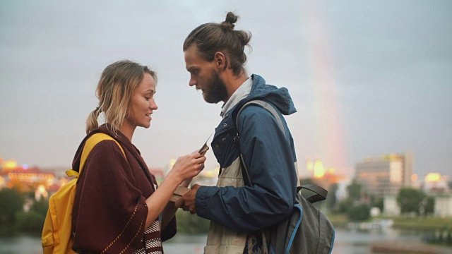 快乐的夫妇在外面玩棋盘游戏。漂亮的男人和女人读着卡片上的任务，面带微笑
