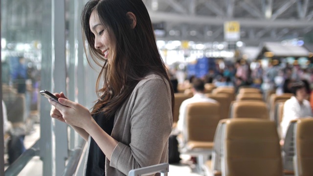 详情图-一名女子在机场使用智能手机