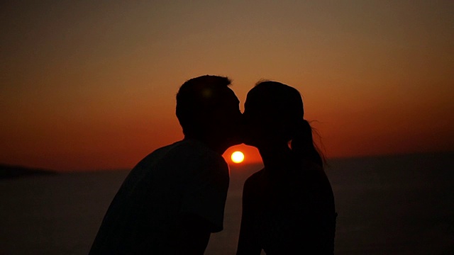 一对浪漫的情侣在夕阳下接吻