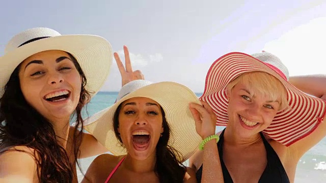 详情图-手持智能手机的女孩欢迎女性在海滩上自拍，戴着草帽的快乐游客在暑假