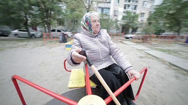 祖母在孩子们的秋千上荡秋千。