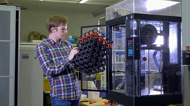 一位工程师正在检查一块巨大的3d打印网格。