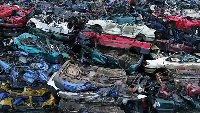 被腐蚀的旧汽车堆放在废品场。