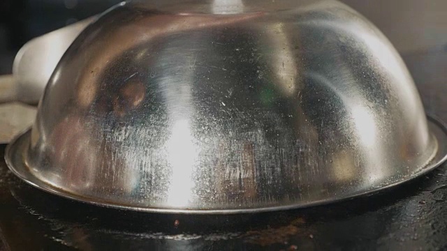 厨师在电烤架上放了两块芝士在汉堡肉排上