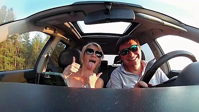 一对年轻夫妇在一个阳光明媚的日子里骑着一辆汽车