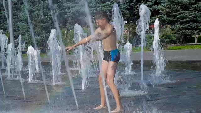 那个男孩正在喷泉里玩