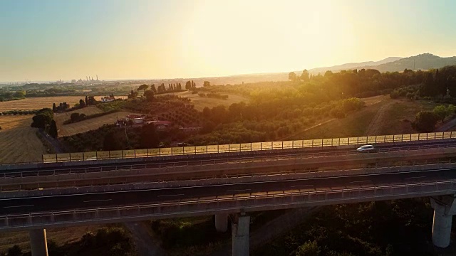 詳情圖-空中拍攝的一個白色卡車與貨物裝載移動在巨大的橋上與交通在農(nóng)村地區(qū)。背景是美麗的自然風(fēng)景。