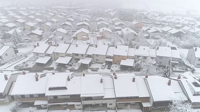 天线:在宁静的郊区城市的屋顶和积雪庭院上空飞行