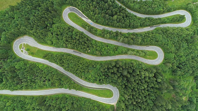 空中摄影:汽车在有急转弯的风景优美的山路上行驶