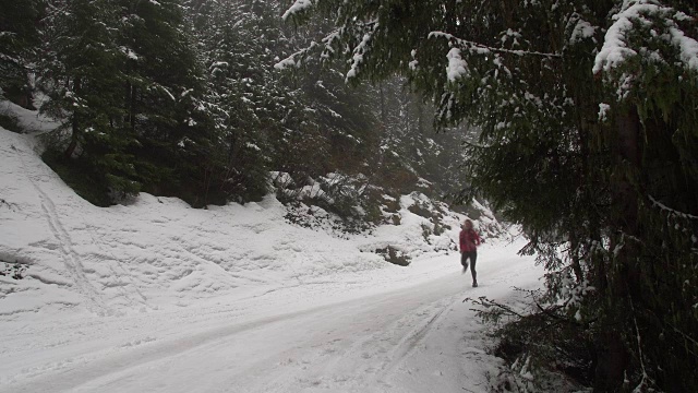 一个女人在雪山路上奔跑。