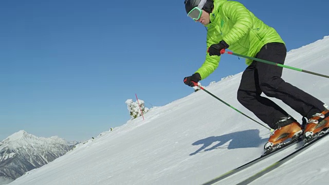 追踪慢动作:年轻的滑雪者在冬天享受着理想的完美天气