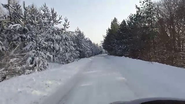 汽车和雪花在冬天的森林道路上有很多雪