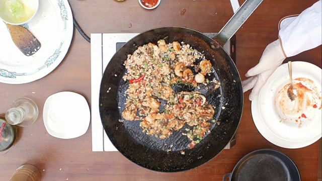 将海鲜饭和海鲜混合在平底锅中烹煮