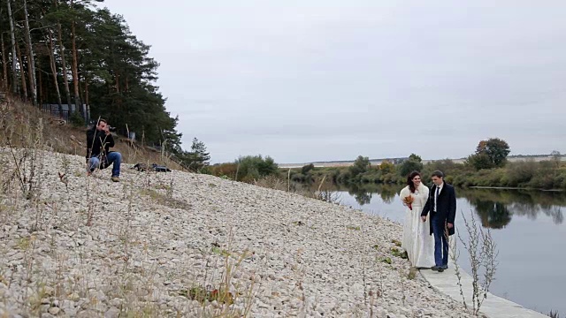 摄影师和新婚夫妇在河边