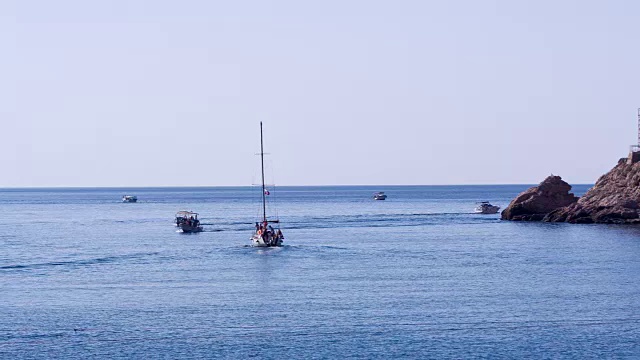 载着游客的船沿着海岸游泳