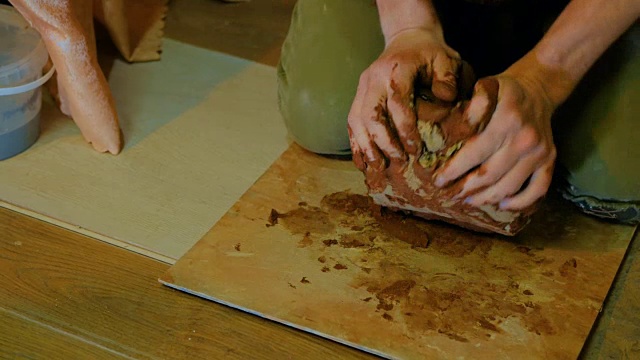 专业男陶工在陶艺作坊捏泥