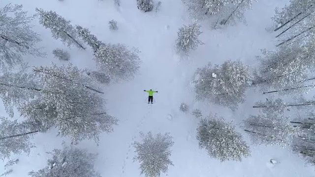 空中女孩冬天在雪山上用新雪制作雪角