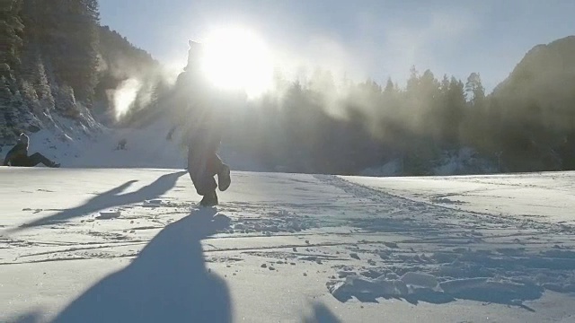 向着夕阳奔上雪坡，慢动作的徒步旅行