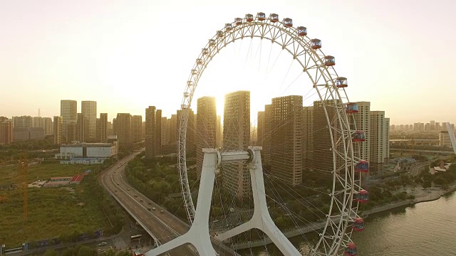 摩天轮横跨河流和现代城市