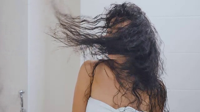 一个女人在浴室里吹干头发